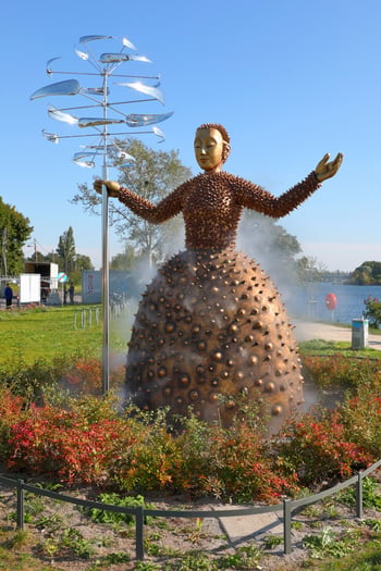 The Water Guardian, a four-metre-tall sculpture holding a windmill with the Old Danube in the background. Photo credit: © C.Stadler/Bwag